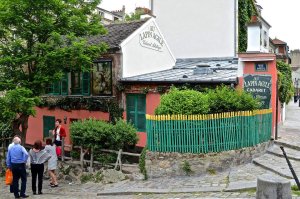 Exterior view of Au Lapin Agile cabaret venue in Paris with illuminated sign