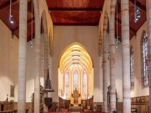 Interior view of the Dominican Church showing gothic arches, altar, and wooden pews