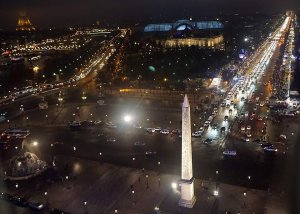 Luxor Obelisk illuminated at night with Grand Palais and Champs-Élysées in Paris