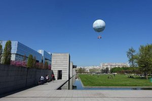 Large helium balloon floating above Parc André Citroën in Paris with clear sky