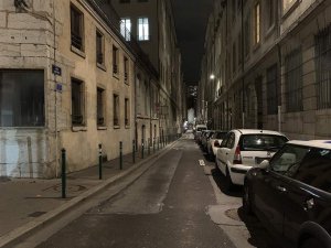 Nighttime view of Rue Royale illuminated by street lamps with buildings along the street