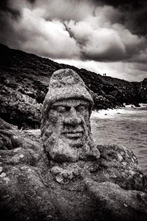 Sculpted rocks with carved figures along the coastline at Rothéneuf