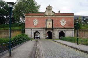 The Porte de Gand, a historic city gate in Lille, France, with brick arches and adjacent old buildings