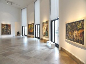 Cubist art display with Jean Metzinger's L'Oiseau Bleu on the left, two André Lhote works in the center, and Albert Gleizes' Les Baigneuses on the right at Musée d'Art Moderne de la Ville de Paris
