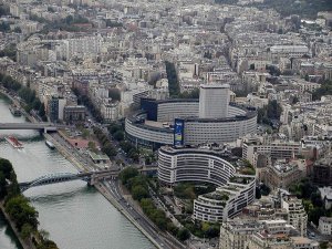 Maison de la Radio building from riverside, featuring circular architecture and surrounding greenery