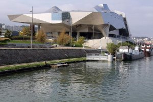Modern stainless steel and glass building resembling a floating crystal cloud at Musée des Confluences in Lyon