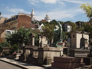 View of Saint-Vincent Cemetery with gravestones and surrounding trees in Paris