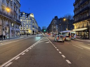 Boulevard Raspail in Paris illuminated at night with street lights and city buildings