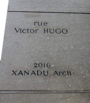 Engraved Rue Victor Hugo street sign with architect signature Xanadu on wall corner in Lyon 2nd arrondissement