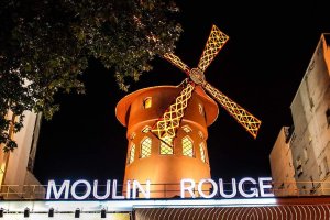 The illuminated Moulin Rouge cabaret building at night in Paris