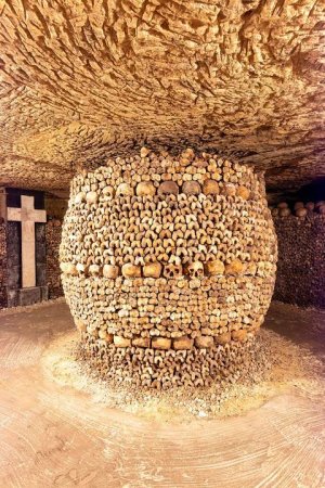 View inside the underground tunnels of the Paris Catacombs showing skulls and bones arranged along the walls