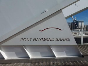 Place name sign and logo on a pillar at Pont Raymond Barre in Lyon