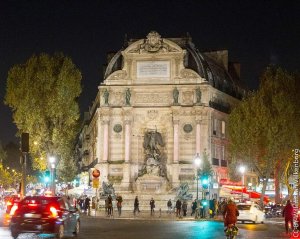 illuminated Fontaine Saint-Michel fountain at night in Paris