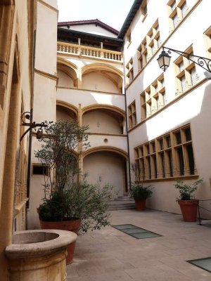 large courtyard of the Gadagne museums with stone buildings and open sky