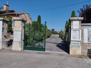 Main entrance gate of Abadie Cemetery in Cannes with stone pillars and an ornate iron gate