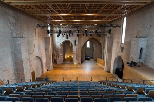 Interior view of the auditorium inside Saint-Pierre-des-Cuisines Church with chairs and architectural details