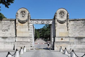 Main entrance gate of Père Lachaise Cemetery with ornate ironwork and stone pillars