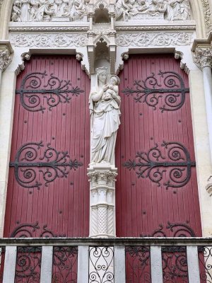 Entrance of Montpellier Cathedral with large gothic stone portal and wooden doors