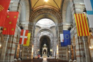 Interior view of Marseille Cathedral featuring an ancient Provence flag