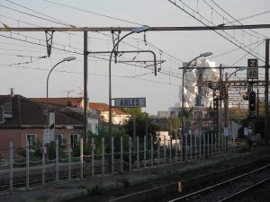 Train station sign at Arles with train tracks and LUMA cultural center designed by Frank Gehry in the background