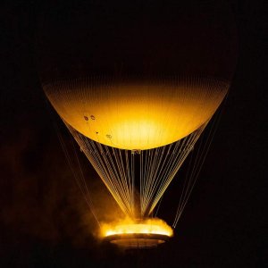 2024 Summer Olympics cauldron floating as a hot air balloon with illuminated misting flame at night