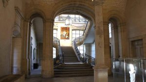 Grand staircase interior of Musee Saint-Remi featuring a portrait of young Louis XIV