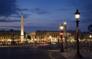 nighttime view of Place de la Concorde with illuminated fountains and surrounding buildings in Paris