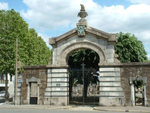 Entrance gates of Nantes La Bouteillerie Cemetery with stone walls and trees