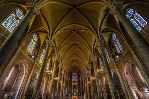 Interior view of Basilique Notre-Dame in Nice showing architectural details and stained glass windows