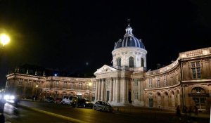 Nighttime view of the Institut de France and Académie des Inscriptions et Belles-Lettres building along Quai de Conti in Paris