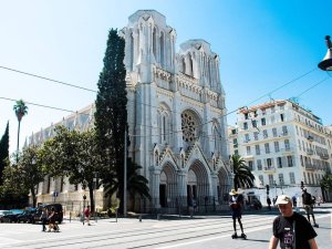 Notre-Dame de l'Assomption Basilica in Nice under a clear blue sky with surrounding city buildings