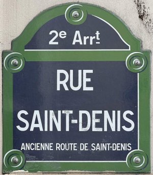 Street sign for Rue Saint-Denis in Paris mounted on a wall