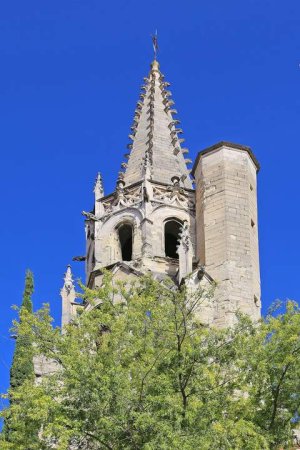 Tower of the parish church Saint Pierre in Avignon, France against a partly cloudy sky