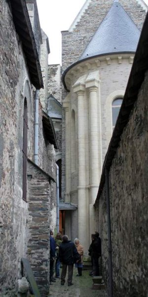 Narrow alley with schist masonry, columns, tuffeau window frames and cornice between Trinity Church and Abbaye du Ronceray in Angers