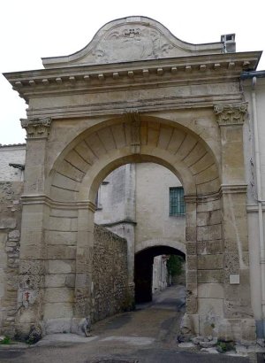 Entrance of the Saint-Césaire Abbey cloister showing historic stone archway surrounded by ancient walls