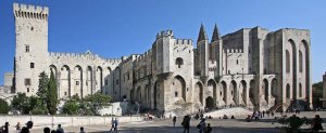 Large medieval stone palace with fortified towers in Avignon