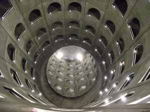 Underground parking area featuring Daniel Buren's 'Sens dessus dessous' art installation with striped columns and vibrant lighting