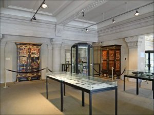 Interior view of a museum hall exhibiting ancient coins, medals, and artifacts