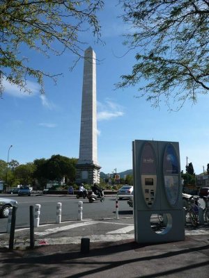 Tall stone obelisk monument in Mazargues, Marseille, surrounded by urban greenery