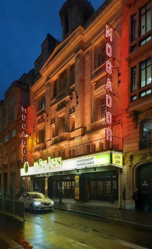 Nighttime view of the illuminated Théâtre Mogador in Paris