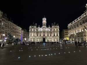 Nighttime view of Place des Terreaux urban square in Lyon with illuminated buildings