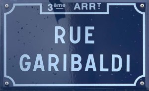 Street name sign for rue Garibaldi mounted on a stone wall