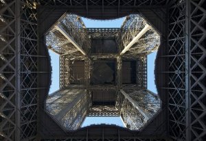 view looking upward through the center structure of the Eiffel Tower