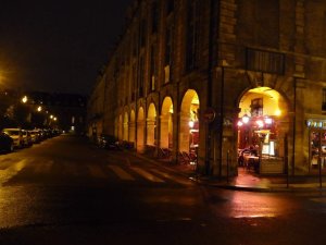 nighttime view of Place des Vosges square in Paris with illuminated historic buildings