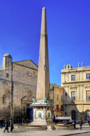 tall obelisk monument standing in the public square of Arles