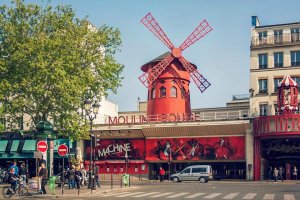 Moulin Rouge building with red windmill and illuminated facade in Paris