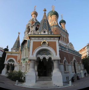 Mosaic artwork visible at the main entrance of the Russian Orthodox Cathedral in Nice, viewed from the park threshold