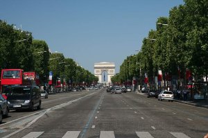 Wide view of Avenue des Champs-Élysées in Paris with tree-lined sidewalks and buildings