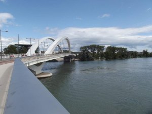 Tramway line T1 crossing Pont Raymond Barre bridge near Museum of Confluences in Lyon