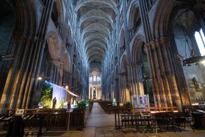 Central nave of Rouen Cathedral showing Gothic arches and stained glass windows